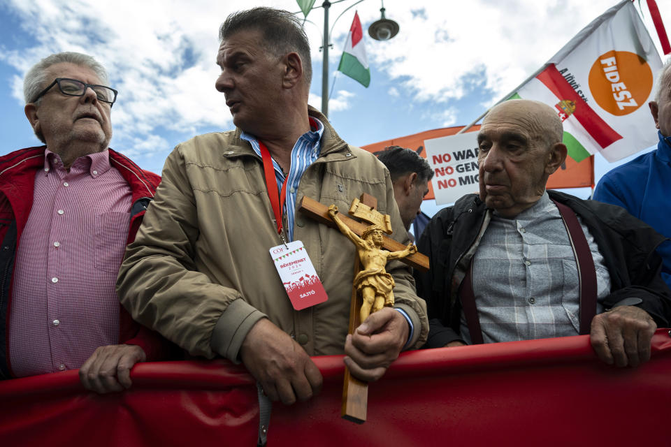 A man holds a crucifix during a "peace march" in support of Prime Minister Viktor Orbán and his party in Budapest, Hungary on Saturday, June 1, 2024. Orbán, whose 14 years in power make him the European Union's longest serving leader, has focused his campaign for the June 9 European Parliament elections on the war in Ukraine, portraying his domestic and international opponents as warmongers who seek to involve Hungary directly in the conflict. (AP Photo/Denes Erdos)