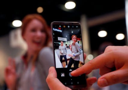 An exhibitor takes a photo with a Huawei Mate 10 Pro during the 2018 CES in Las Vegas, Nevada, U.S. January 9, 2018. REUTERS/Steve Marcus