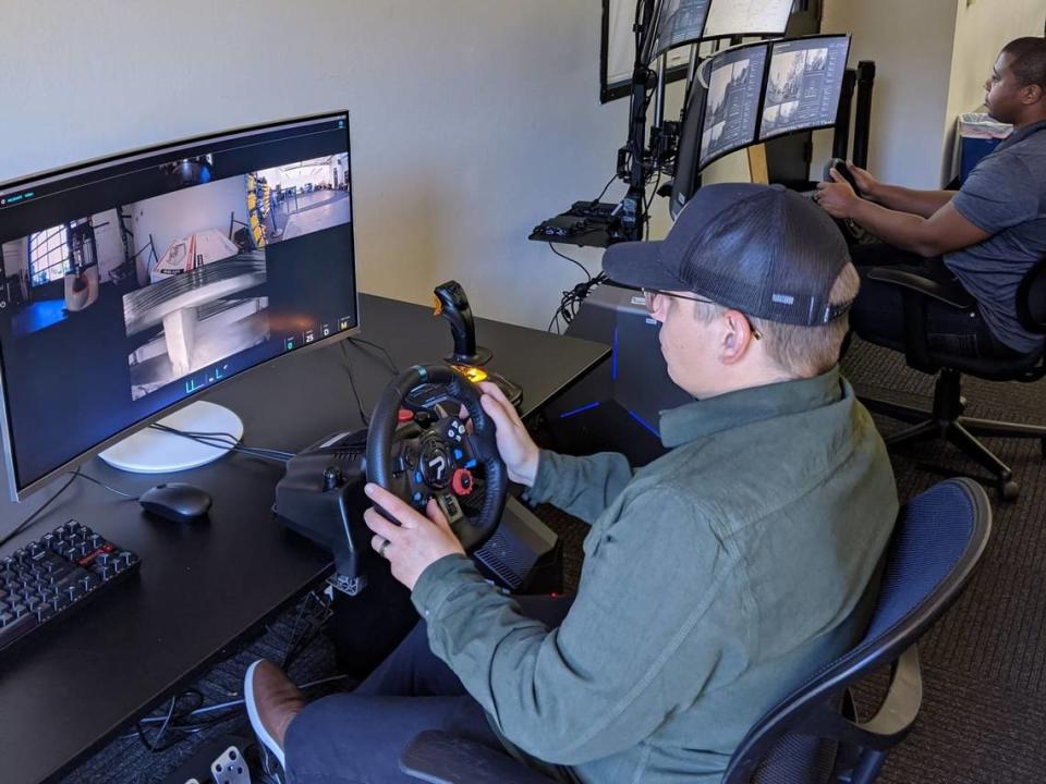 A driver remotely operates a forklift. Large equipment and logistics companies like Mitsubishi are deploying such technologies in their warehouses.