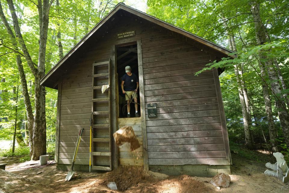 Travis Miller drops a block of ice from one of two ice houses at Rockywold Deephaven Camps, Thursday, June 20, 2024, in Holderness, N.H. (AP Photo/Robert F. Bukaty)