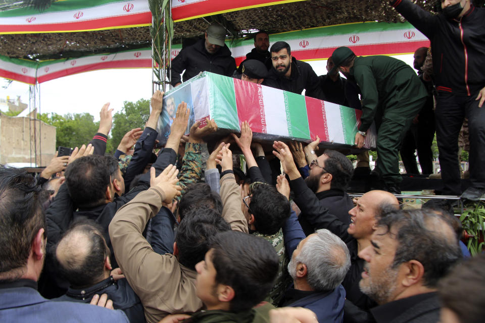 In this photo provided by Fars News Agency, mourners carry the flag-draped coffin of Iranian Foreign Minister Hossein Amirabdollahian, who was killed in a helicopter crash along with President Ebrahim Raisi on Sunday in a mountainous region of the country's northwest, during a funeral ceremony at the city of Tabriz, Iran, Tuesday, May 21, 2024. Mourners in black began gathering Tuesday for days of funerals and processions for Iran's late president, foreign minister and others killed in a helicopter crash, a government-led series of ceremonies aimed at both honoring the dead and projecting strength in an unsettled Middle East. (Ata Dadashi, Fars News Agency via AP)