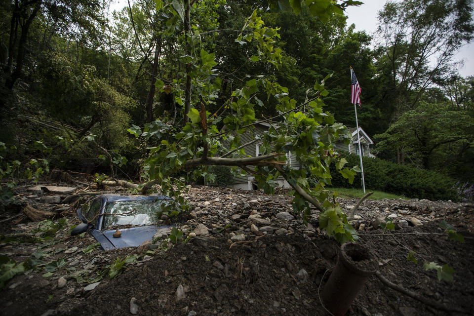 A car is buried in mud and rocks from recent flooding, Monday, July 17, 2023, in Belvidere, N.J. Scientists say increasingly frequent and intense storms could unleash more rainfall in the future as the atmosphere warms and holds more moisture. (AP Photo/Eduardo Munoz Alvarez)