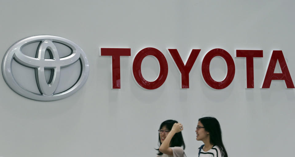 Visitors walk at a Toyota gallery in Tokyo Thursday, May 8, 2014. Toyota's fourth quarter profit dropped slightly despite higher vehicle sales and a weak yen as it spend more on research and development. Toyota Motor Corp. reported Thursday a January-March profit of 297 billion yen ($2.9 billion), down from 313.9 billion yen a year earlier. Quarterly sales rose 12.5 percent to 6.57 trillion yen ($64.5 billion). (AP Photo/Koji Sasahara)