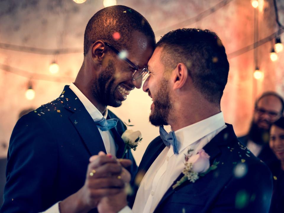 two grooms dancing with each other at their wedding