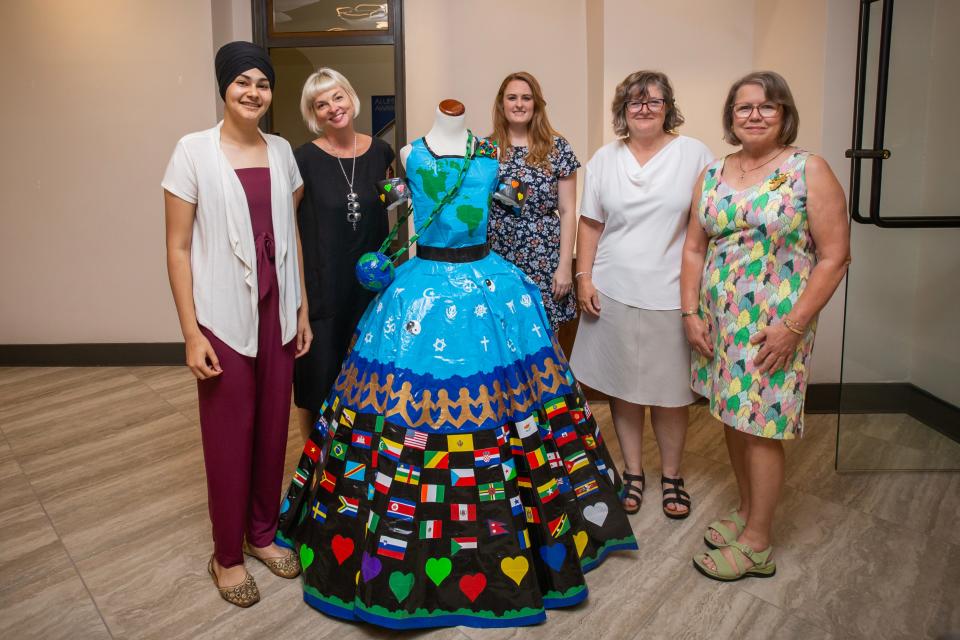 Ritika Singh, Mount Mary fashion department chair Ashley Brooks, archivist Amanda Cacich, university president Isabelle Cherney and retired archivist Mary Elliot Nowakowski pose in front of Singh's duct tape dress, which she has donated to Mount Mary.