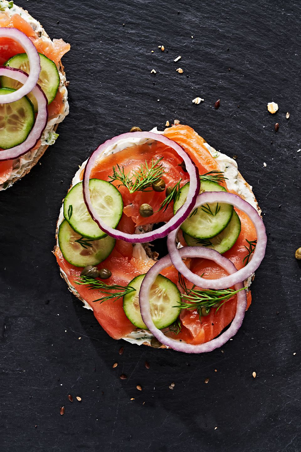 bagel and lox topped with tomato, cucumber, capers and onion