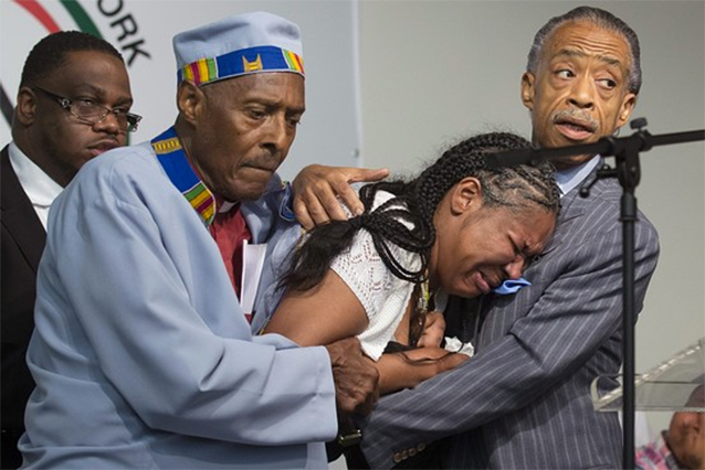 Esaw Garner, the wife of Eric Garner, cries in the arms of Rev. Al Sharpton at a rally Saturday. Photo: AP