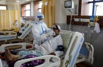 FILE PHOTO: A medical worker takes care of a patient suffering from the coronavirus disease (COVID-19), at a hospital in Noida