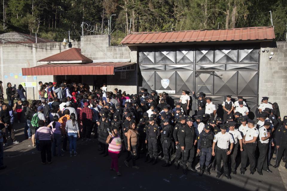 FILE - In this March 8, 2017 file photo, National Police guard the entrance to the Virgen de la Asuncion Safe Home, in San Jose Pinula, Guatemala. In November, a state human rights prosecutor filed a complaint with the Inter American Human Rights Commission charging rampant abuses at the shelter. The accusations included charges as serious as "forced recruitment for human trafficking for the purpose of prostitution." (AP Photo/Luis Soto, File)