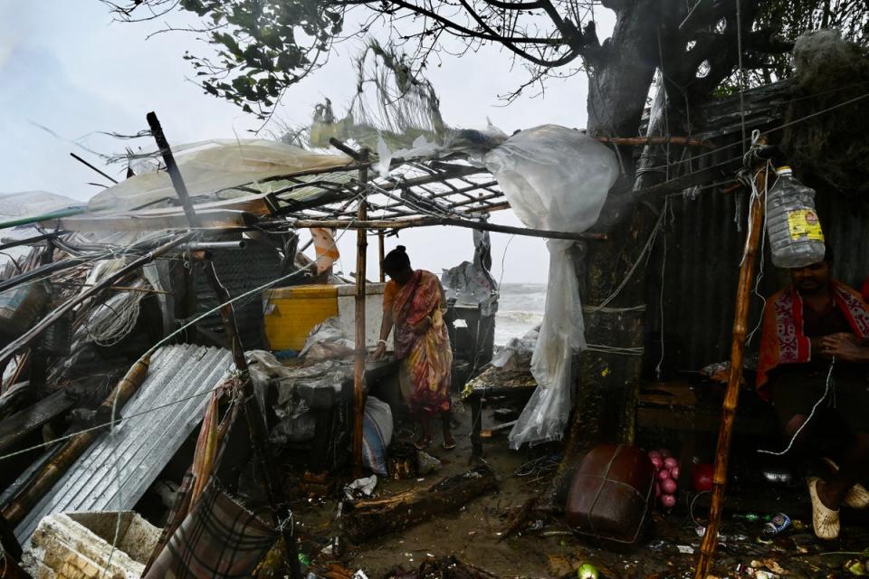 A woman stands next to her damaged house after cyclone Remal made landfall near a beach in Kuakata (AFP via Getty)