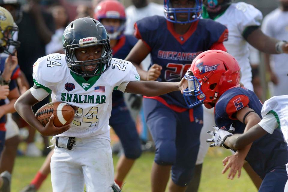 A Shalimar player can be seen giving a stiff arm to a Fort Walton Beach player. This game was the fifth meeting in the "Battle of the Bridges" series