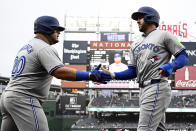 Toronto Blue Jays' George Springer, right, is greeted by Daniel Vogelbach, left, after scoring on a single by Justin Turner during the first inning of a baseball game against the Washington Nationals, Saturday, May 4, 2024, in Washington. (AP Photo/Nick Wass)
