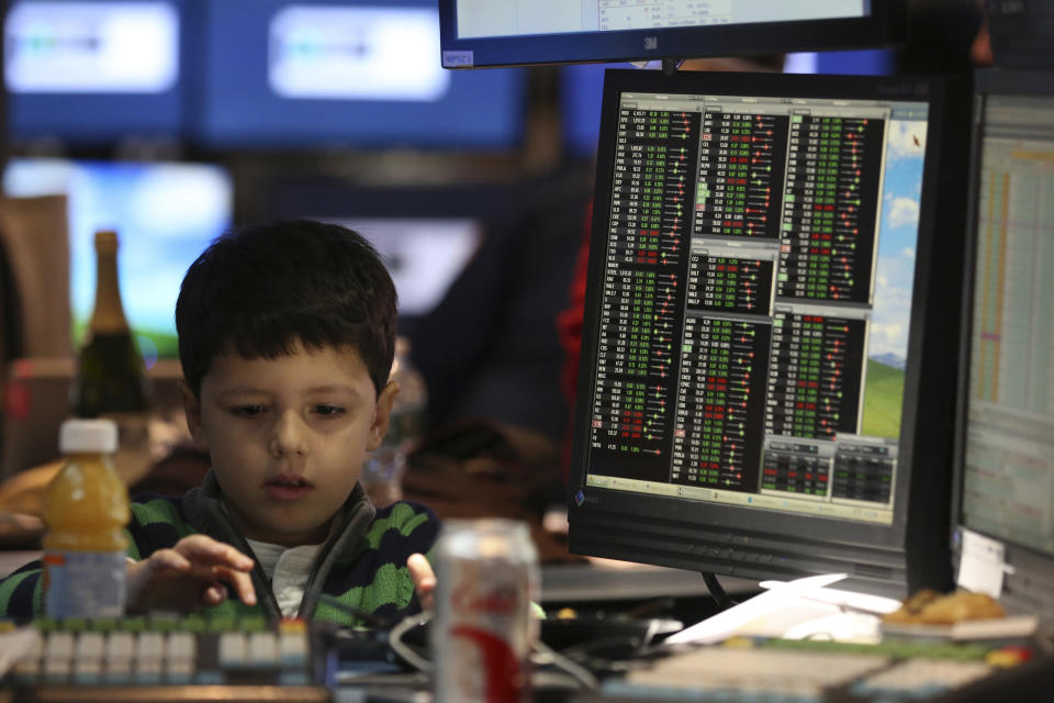 A young boy works at a post on the floor of the New York Stock Exchange November 29, 2013. Traders traditionally bring their kids to work for the half day of trading on the Friday after the Thanksgiving holiday.  REUTERS/Brendan McDermid (UNITED STATES - Tags: BUSINESS)