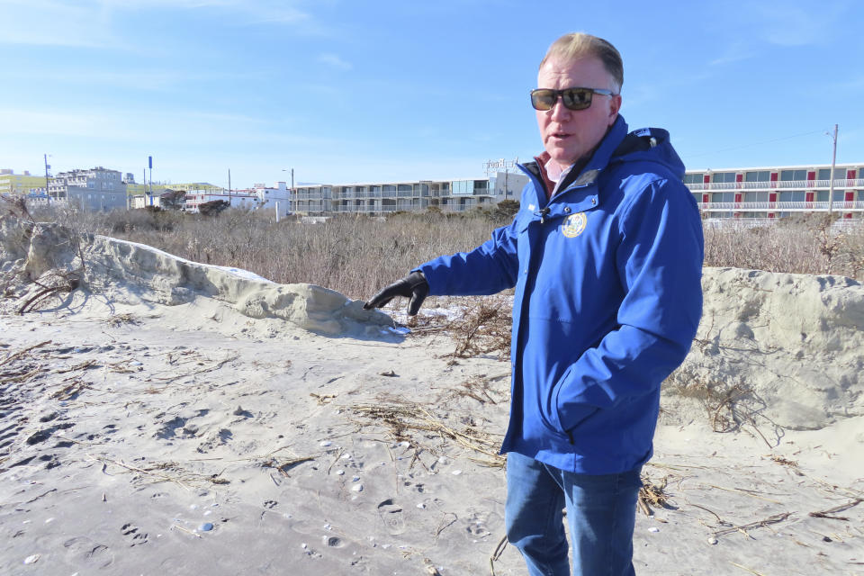 Mayor Patrick Rosenello points to a destroyed section of sand dune in North Wildwood N.J. on Jan. 22, 2024. A recent winter storm punched a hole through what is left of the city's eroded dune system, leaving it more vulnerable than ever to destructive flooding as the city and state fight in court over how best to protect the popular beach resort. (AP Photo/Wayne Parry)