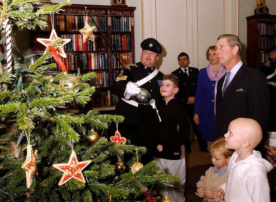 <p>Prince Charles hosts a Christmas party with children suffering from Leukemia. Here, the kids watch Sergeant Mark Bevan of the Queen's Dragoon put ornaments on the tree with his sword.</p>