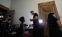 A model gets her make-up done in the backstage at the "We are Made in Italy - Black Lives Matter in Italian fashion Collection" event during the Milan's fashion week in Milan, Italy, Thursday, Sept. 17, 2020. (AP Photo/Antonio Calanni)