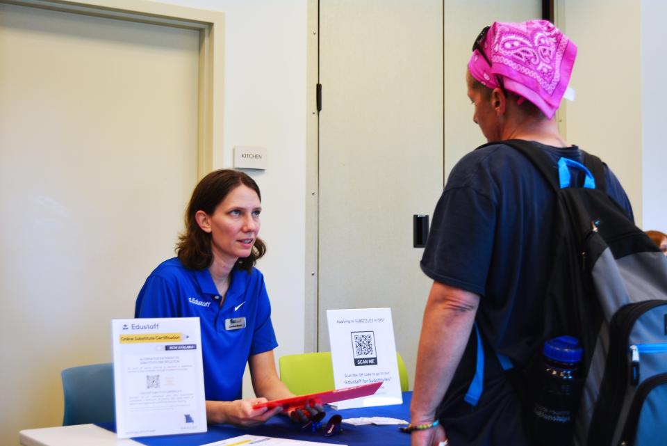 Carissa Keedy, left, with EduStaff chats Wednesday with a visitor at the Columbia Job Center's hiring event at Daniel Boone Regional Library in Columbia. Eleven employers were on-site for the event.