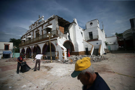 People are seen next to a damaged building after an earthquake, in Jojutla de Juarez, Mexico September 21, 2017. REUTERS/Edgard Garrido