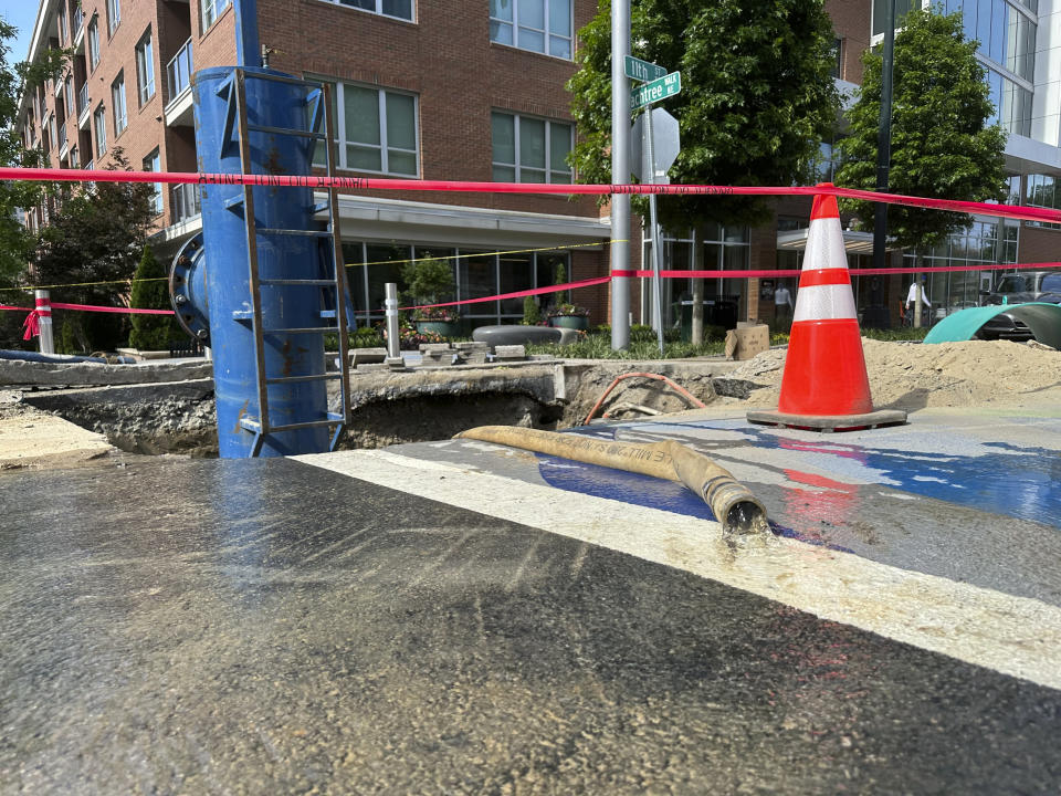 Water trickles out of a hose attached to a device that shuts off flow to a water main on Monday, June 3, 2024, in Atlanta. The device was one of several used to shut off flow to a leak that had gushed for more than two days in Atlanta's Midtown neighborhood. (AP Photo/Jeff Amy)