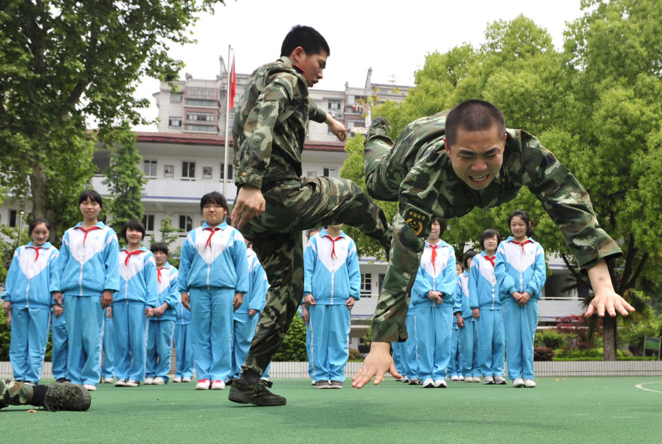 Paramilitary policemen demonstrate self-defence skills to students at a school in Nanjing, Jiangsu province May 6, 2010. China's police forces nationwide were ordered to step up security of kindergartens and schools after a spate of violent attacks against school children last week, Xinhua News Agency reported. REUTERS/Stringer (CHINA - Tags: MILITARY EDUCATION IMAGES OF THE DAY) CHINA OUT. NO COMMERCIAL OR EDITORIAL SALES IN CHINA