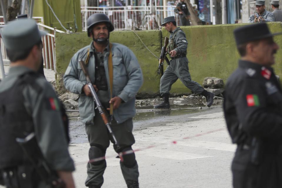 Afghan police men block the street after a suicide bomber wearing a military uniform struck the entrance gate of the Interior Ministry compound in Kabul, Afghanistan, Wednesday, April 2, 2014. Ministry of Interior spokesman Sediq Sediqqi said the bomber, who was wearing a military uniform to evade security checks, reached the entrance of the heavily fortified ministry compound before detonating his explosives. (AP Photo/Massoud Hossaini)