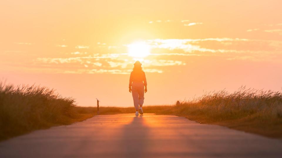 woman walking at sunrise