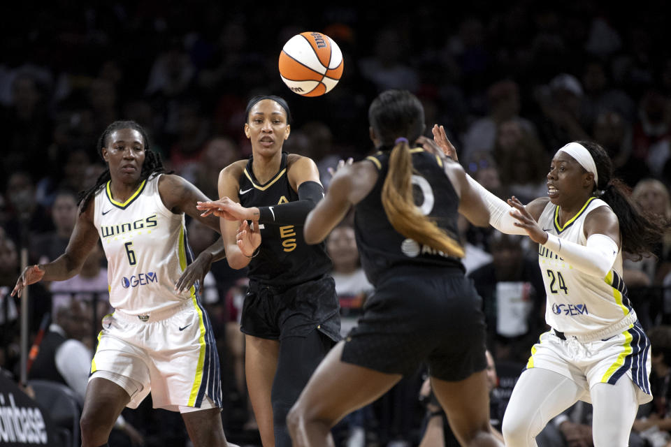 Las Vegas Aces forward A'ja Wilson, center left, passes to guard Jackie Young while Dallas Wings forward Natasha Howard (6) and guard Arike Ogunbowale (24) defend during the first half in Game 1 of a WNBA basketball semifinal series, Sunday, Sept. 24, 2023, in Las Vegas. . (Ellen Schmidt/Las Vegas Review-Journal via AP)