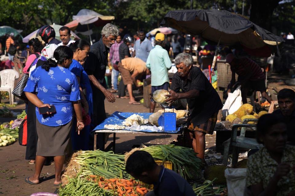 People buy vegetables in Colombo, Sri Lanka, Wednesday, Dec. 13, 2023. The International Monetary Fund executive board has approved the release of $ 337 million second tranche of a bailout package to help Sri Lanka recover from its worst economic crisis. (AP Photo/Eranga Jayawardena)