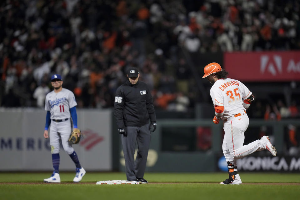 San Francisco Giants' Brandon Crawford, right, runs the bases after hitting a solo home run against the Los Angeles Dodgers during the eighth inning of a baseball game in San Francisco, Tuesday, April 11, 2023. (AP Photo/Godofredo A. Vásquez)