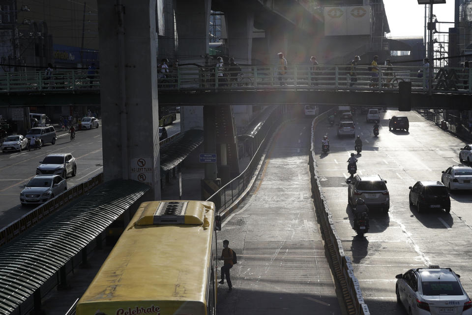 A man rides a bus in Quezon city, Philippines, Saturday, Sept. 26, 2020. Public transportation remains limited and the government orders commuters to wear face shields and face masks to help curb the spread of the coronavirus. (AP Photo/Aaron Favila)