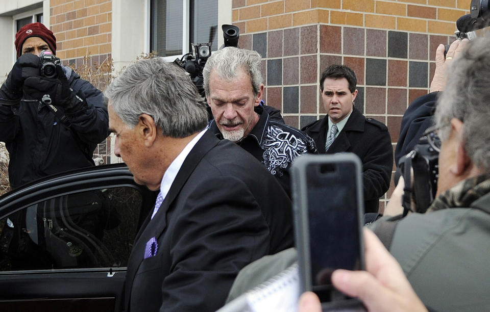 Attorney James Voyles, center left, and Indianapolis Colts owner Jim Irsay, center right, leave the Hamilton County Jail in Indianapolis, Monday, March 17, 2014. Irsay was released from jail Monday after being held overnight following a traffic stop in which police said he failed sobriety tests and had multiple prescription drugs inside his vehicle. Irsay was pulled over late Sunday after he was spotted driving slowly near his home in suburban Carmel, stopping in the roadway and failing to use a turn signal. (AP Photo/Alan Petersime)