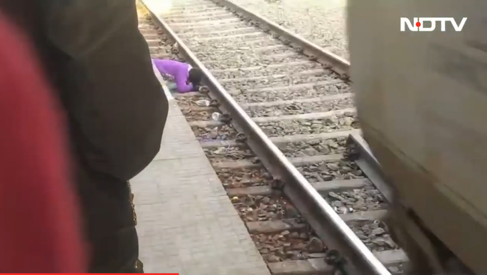 A woman in India sheilds her children from the train (NDTV)