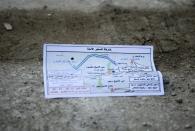 A flyer bearing a map reportedly distributed by the government encouraging people to leave a rebel-held area of the northern embattled city of Aleppo is seen lying in the street