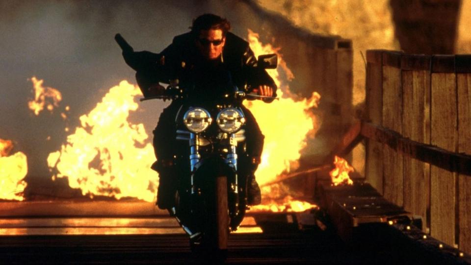 ethan hunt rides a motorcycle through fire in a scene from mission impossible 2 it is the second film if you're watching the mission impossible movies in order