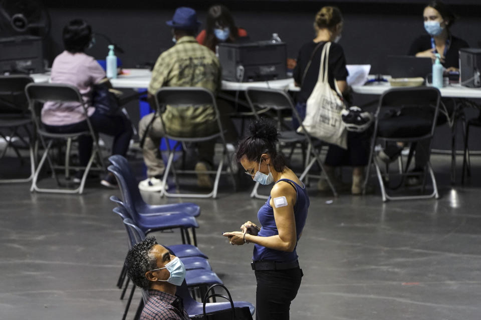 People wait after receiving the Pfizer-BioNTech COVID-19 vaccine, in a vaccination center of Lyon, central France, Wednesday, July 7, 2021. French government spokesperson Gabriel Attal said the epidemic is gaining ground again in France due to the delta variant, after several months of decrease. (AP Photo/Laurent Cipriani)