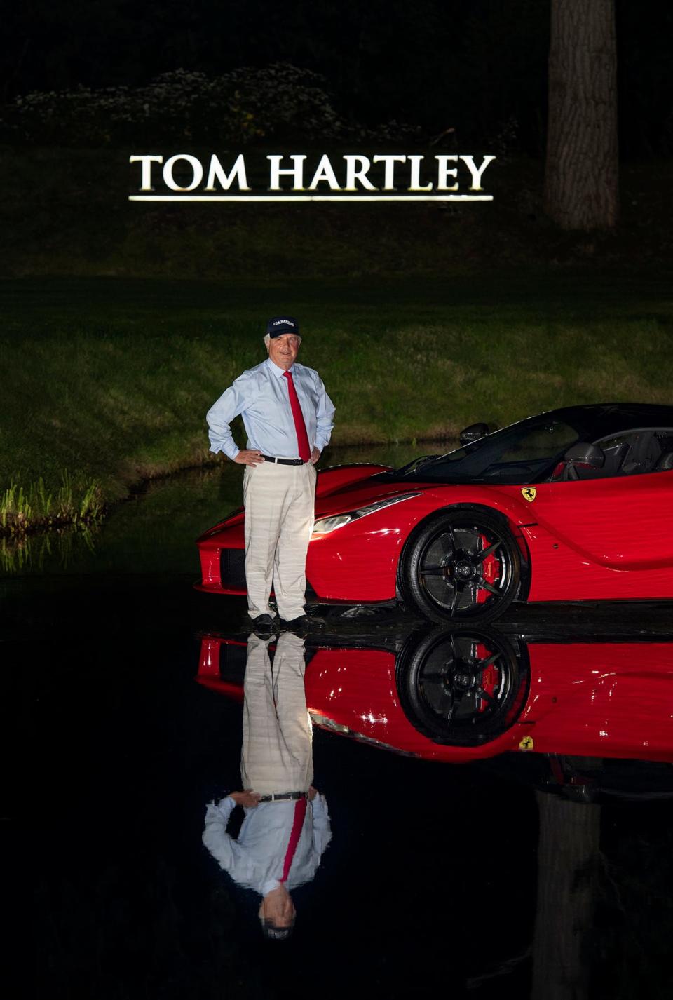 man standing in front of a red car