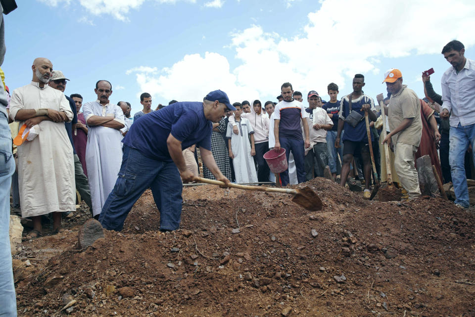 People dig graves during a funeral of residents who died in a flash flood in Tizert, near the southern region of Taroudant, Morocco. Thursday, Aug. 29, 2019. Morocco's official MAP news agency says that seven people watching a local soccer match in a southern village have died in a flash flood that swept across a football field on Wednesday evening. (AP Photo/Mohamed Amerkad)