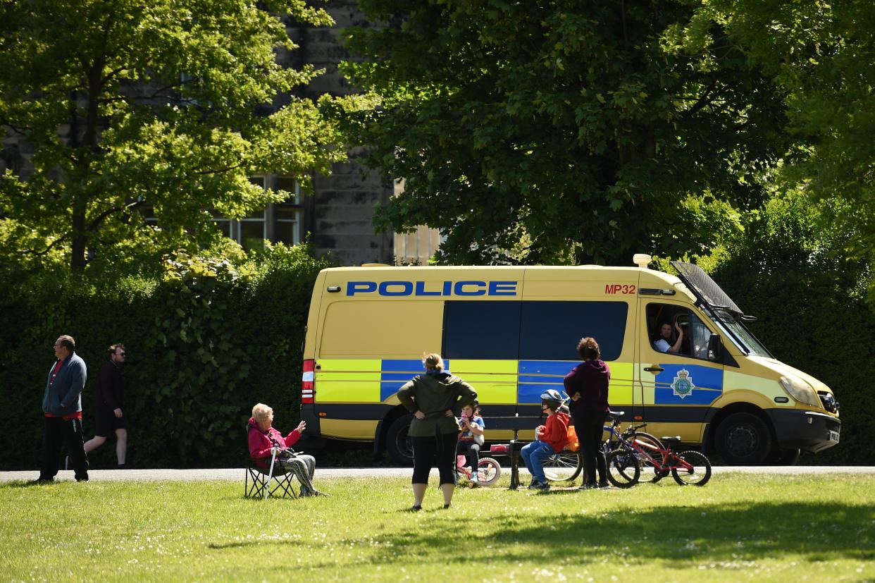 A police officer speaks to people in Birkenhead Park, Merseyside on May 16, 2020, following an easing of lockdown rules in England during the novel coronavirus COVID-19 pandemic. - People are being asked to 
