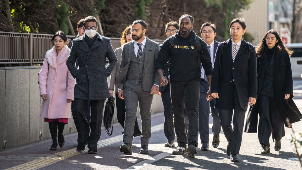 The three plaintiffs and their legal team walk outside the Tokyo District Court on January 29, 2024. - Philip Fong/AFP/Getty Images