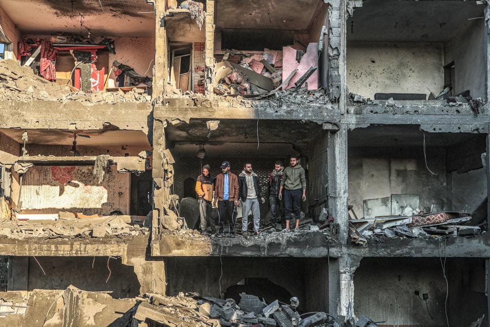 Palestinians check a half destroyed building following Israeli bombardment on Rafah, in the southern Gaza Strip, on December 15, 2023, amid continuing battles between Israel and the Palestinian militant group Hamas.