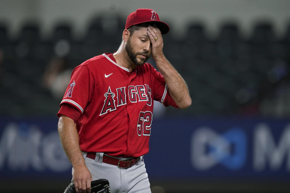 Los Angeles Angels relief pitcher Ryan Tepera wipes his face as he walks to the dugout after being pulled during the eighth inning of the team's baseball game against the Texas Rangers, Tuesday, May 17, 2022, in Arlington, Texas. (AP Photo/Tony Gutierrez)