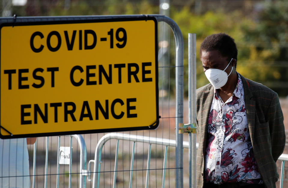 A man stands near a sign for a COVID-19 test centre in Bolton, Britain. Photo: Phil Noble/Reuters