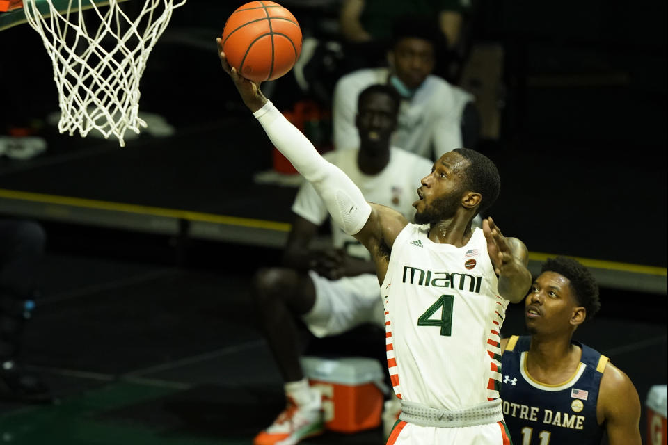 Miami guard Elijah Olaniyi (4) drives to the basket over Notre Dame forward Juwan Durham (11) during the first half of an NCAA college basketball game, Sunday, Jan. 24, 2021, in Coral Gables, Fla. (AP Photo/Marta Lavandier)