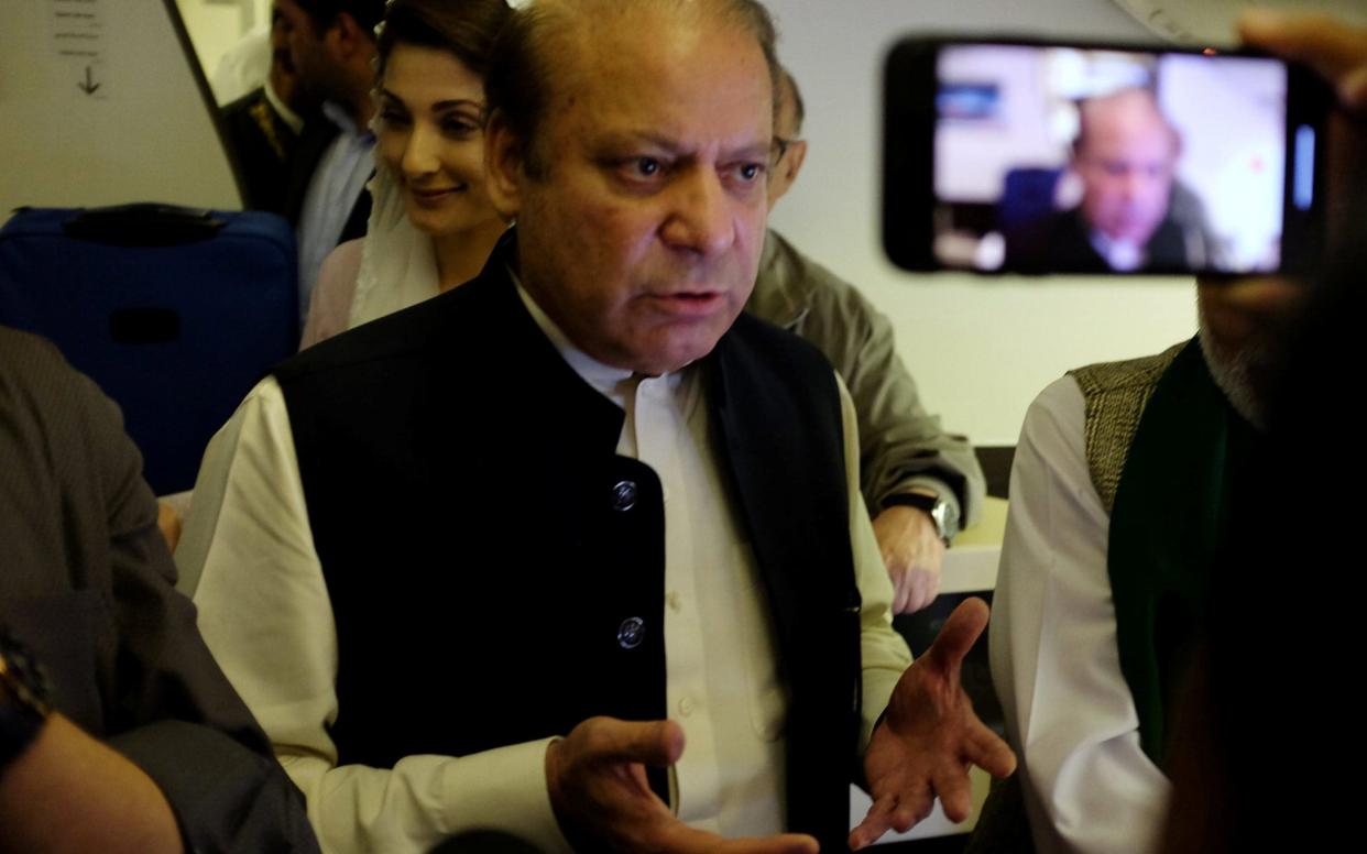 Ousted Pakistani Prime Minister Nawaz Sharif gestures as he boards a Lahore-bound flight from Abu Dhabi  - REUTERS