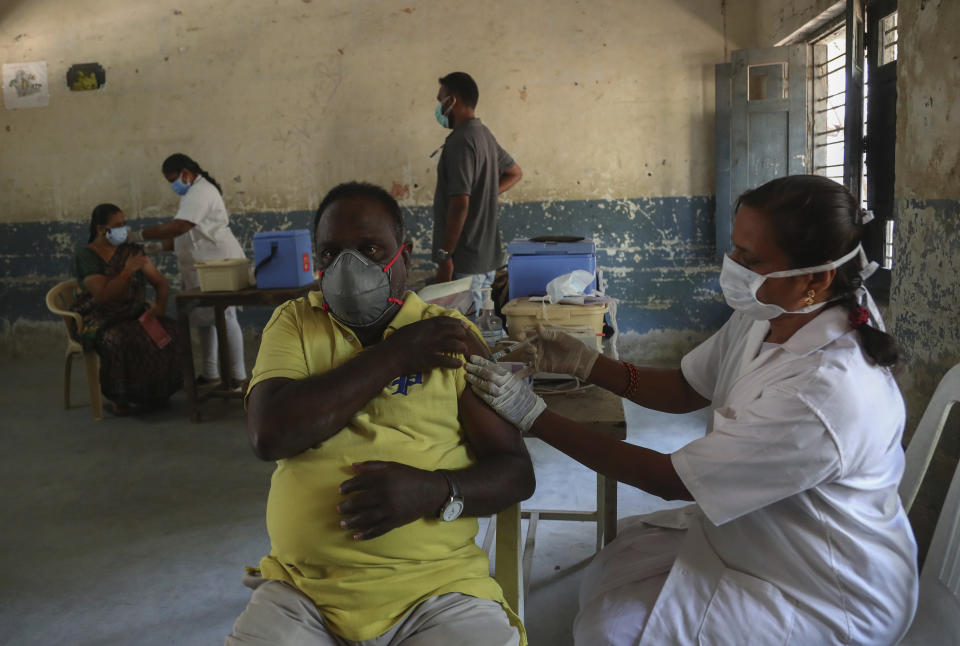 A health worker administers Covishield, Serum Institute of India's version of the AstraZeneca vaccine to a man during a special vaccination drive held in the premises of a government school in Hyderabad, India, Sunday, May 30, 2021. (AP Photo/Mahesh Kumar A.)