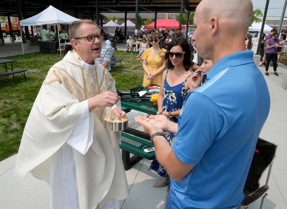 The Rev. Tim Kitzke serves Communion at a polka-themed Mass during Crusherfest, a festival celebrating the legacy of South Milwaukee native and wrestling legend Reggie “The Crusher” Lisowski, on June 4. 2023.
