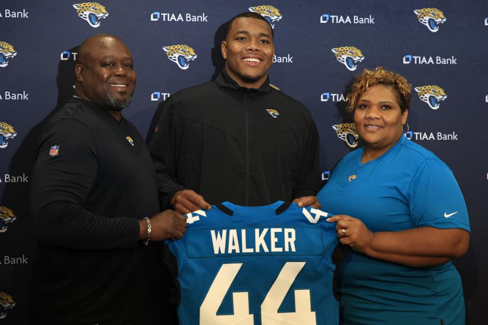 University of Georgia star Travon Walker, the No. 1 pick by the Jaguars in the NFL draft, shows off his No. 44 jersey with his father and mother, Stead Walker and Lasonia Walker, by his side. He was the first of a record 15 Georgia selections and 65 from the SEC in the draft.