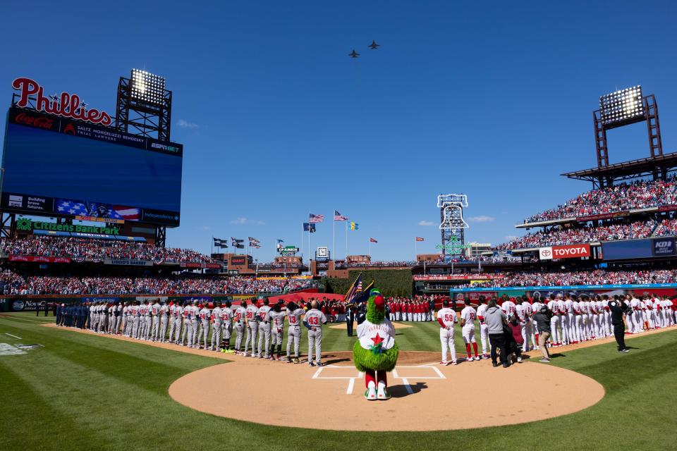 The Philadelphia Phillies and Atlanta Braves stand for the anthem as jets fly overhead on opening day at Citizens Bank Park