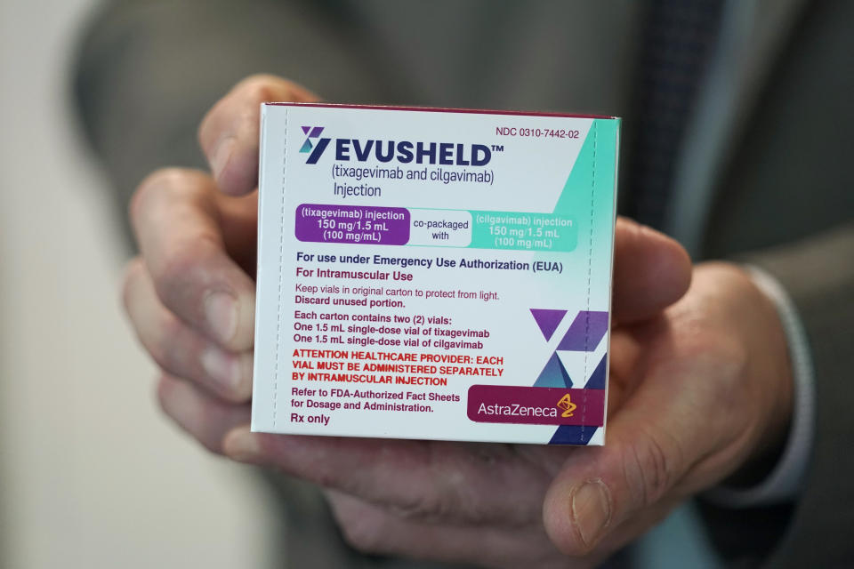 Scott Madow, a heath services manager at a University of Washington Medicine clinic, poses for a photo as he holds a box of AstraZeneca's Evusheld, the first set of antibodies grown in a lab to prevent COVID-19, Thursday, Jan. 20, 2022, in Seattle. A two-shot dose of the drug is supposed to give immune-compromised patients who can't make their own virus-fighters some protection against COVID-19 for six months. (AP Photo/Ted S. Warren)