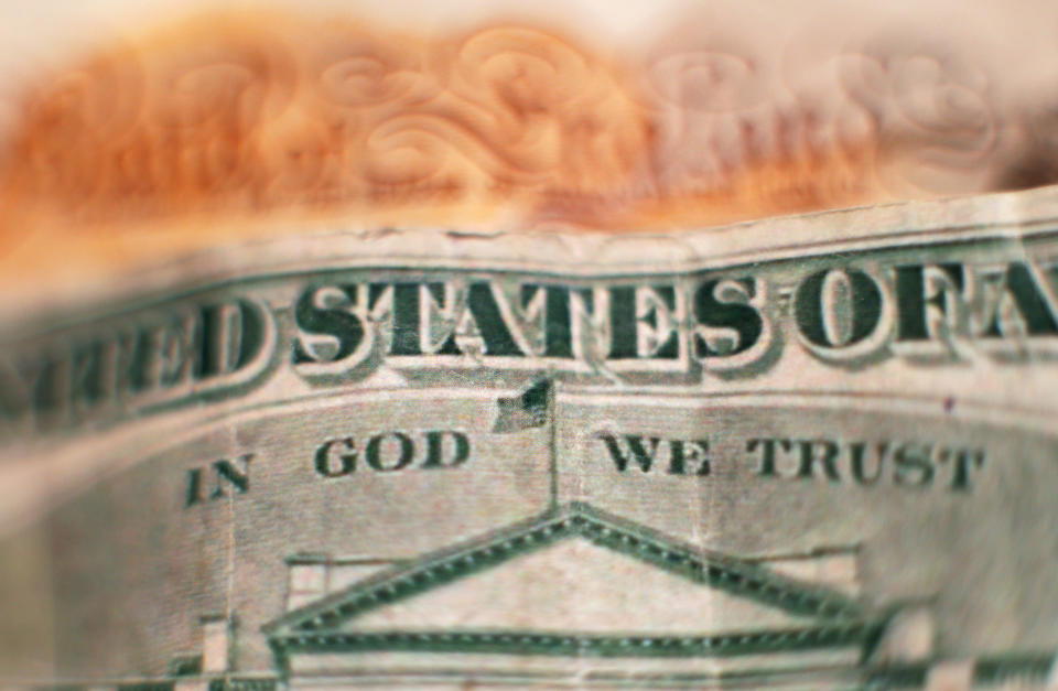 The design on the reverse of a twenty dollar bill, featuring the official motto of the United States "In God We Trust" above a depiction of the White House, placed in front of a ten pound note, in north London. PRESS ASSOCIATION Photo. Picture date: Friday January 27, 2017. Photo credit should read: Yui Mok/PA Wire